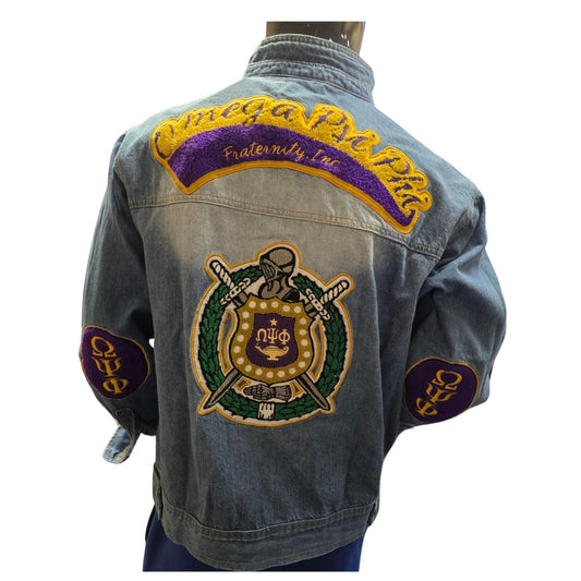 Denim jacket with embroidered patches on a white background