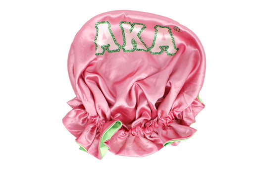 KA pink and green satin hair bonnet laid flat, showing interior lining and sorority letter detailing