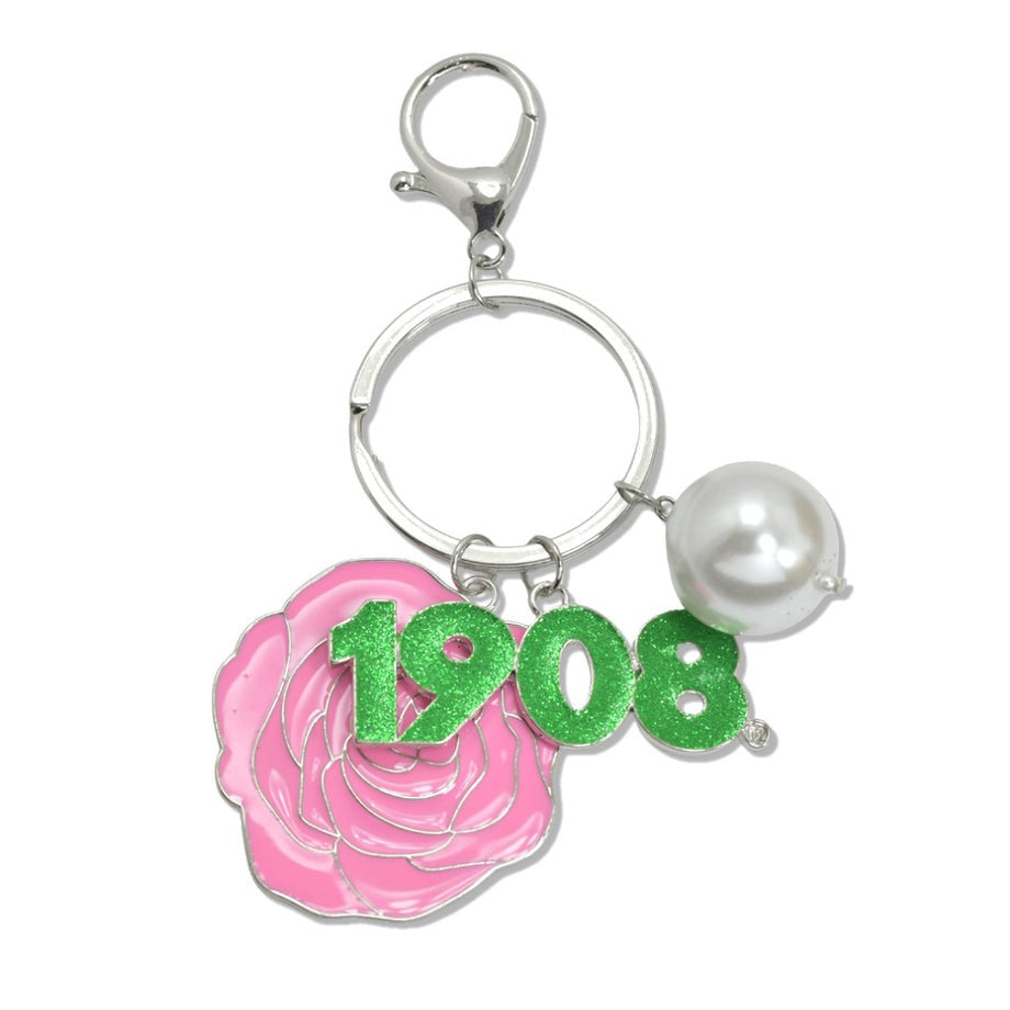 Close-up of AKA paraphernalia keychain showing pearl, rose, and 1908 founding date charms.