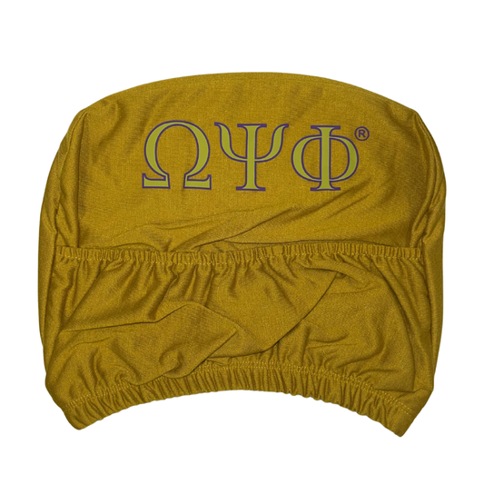 Back of an Omega Psi Phi gold car headrest cover showing the purple and gold Greek letters Omega Psi Phi in a simple, large font, with elastic gathering at the bottom and a pocket detail.