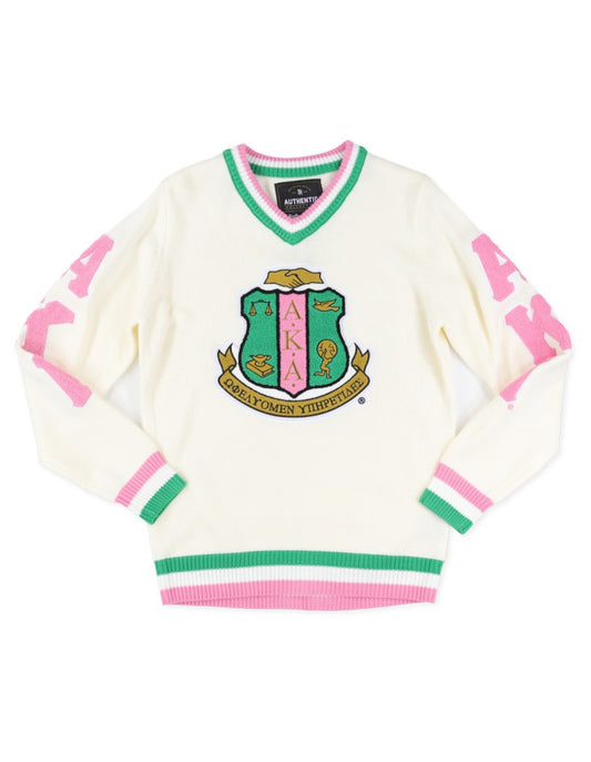 AKA Ivory sweater with pink and green accents and a crest design on a white background