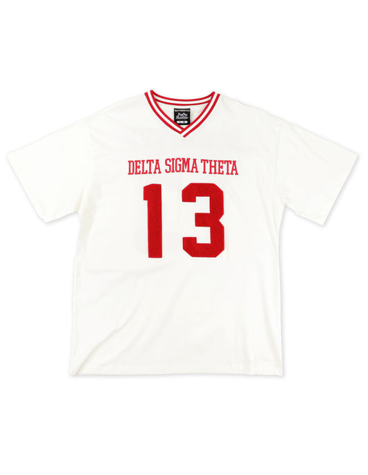 Front view of a white Delta Sigma Theta V-neck jersey t-shirt with red striped trim. The shirt features "DELTA SIGMA THETA" and the number "13" in red, varsity-style font.