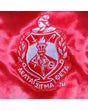 Close-up view of the white embroidered Delta Sigma Theta Sorority crest on a red satin fabric background.