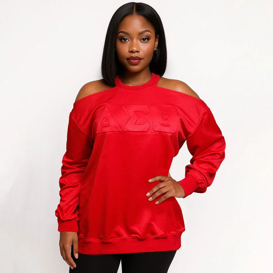 Red cold-shoulder sweatshirt with large, embossed Delta Sigma Theta (DST) Greek letters on the chest, modeled by a woman.