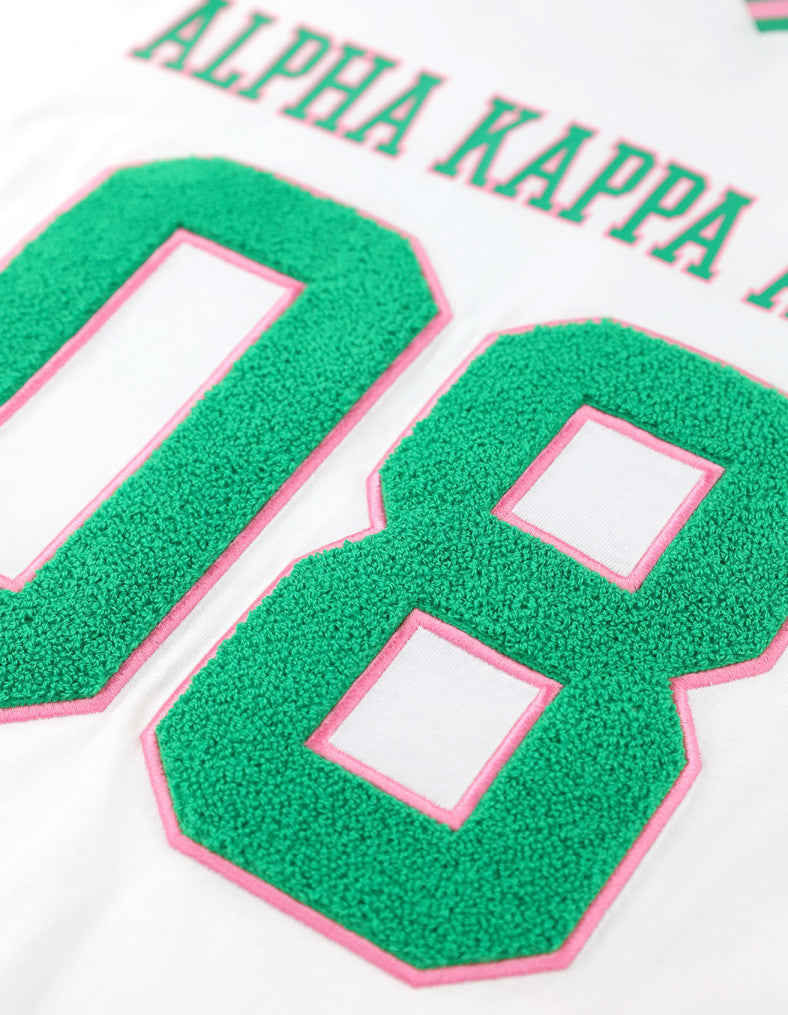 Back view of AKA Loose-Fit Jersey Tee in Ivory with printed IVY LEAF and green "08" numbers.