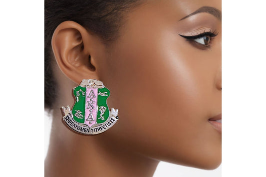 "Pink and green AKA sorority crest stud earrings in silver-toned metal."