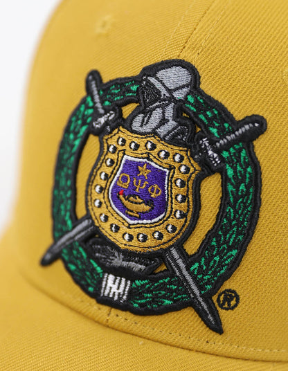 Gold Omega Psi Phi Cap with shield closeup. 