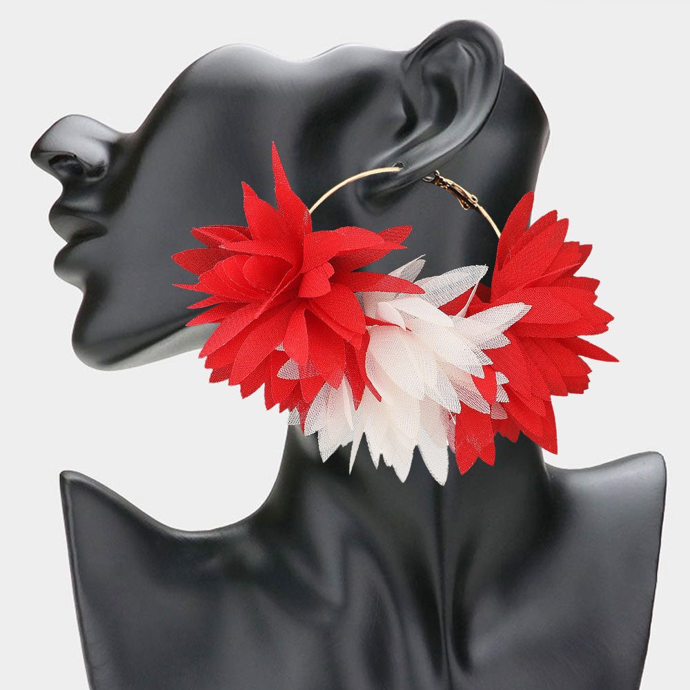Side profile view of oversized red and white fabric floral hoop earrings displayed on a black mannequin bust, featuring layered petals and a gold omega back.