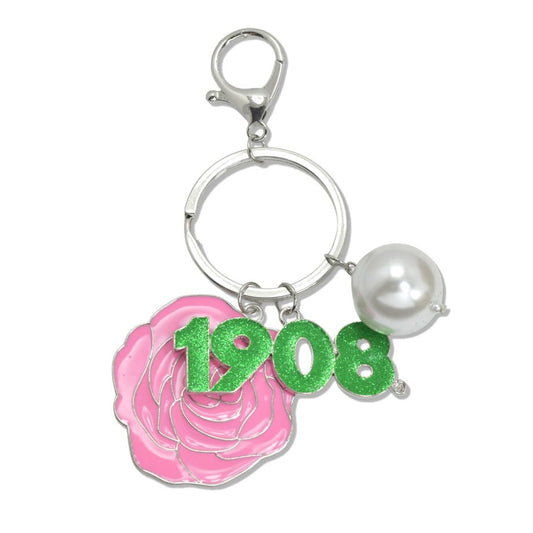 Close-up of AKA paraphernalia keychain showing pearl, rose, and 1908 founding date charms.